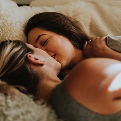 women kissing in bed