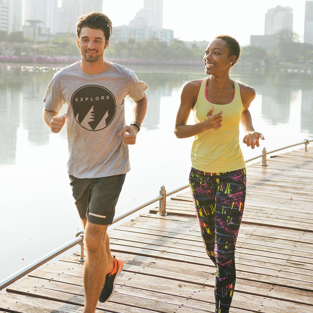 Couple running together on a boardwalk